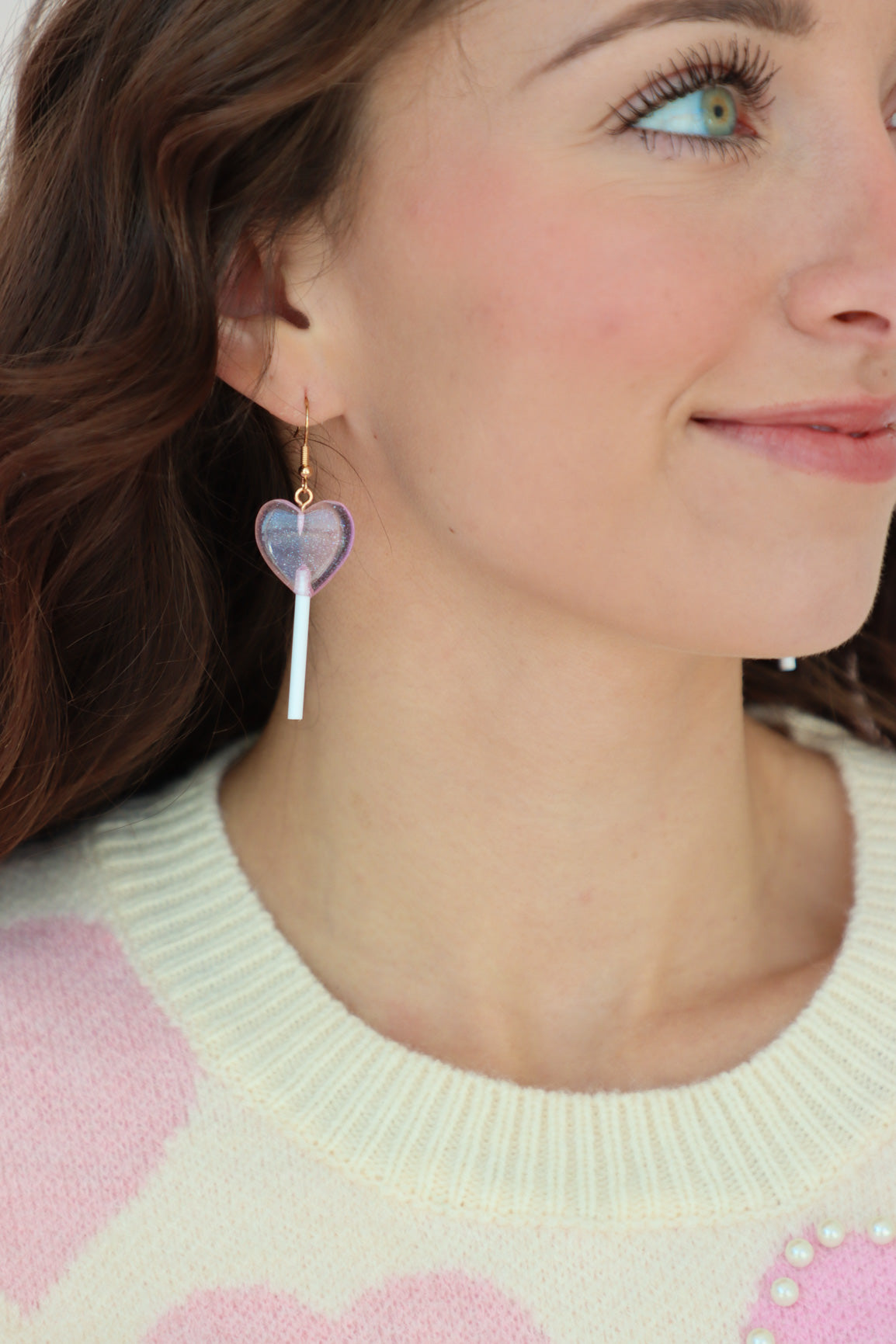 girl wearing pink heart-shaped lollipop earrings
