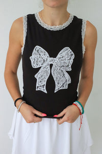 girl wearing black tank top with white lace trim & bow detailing