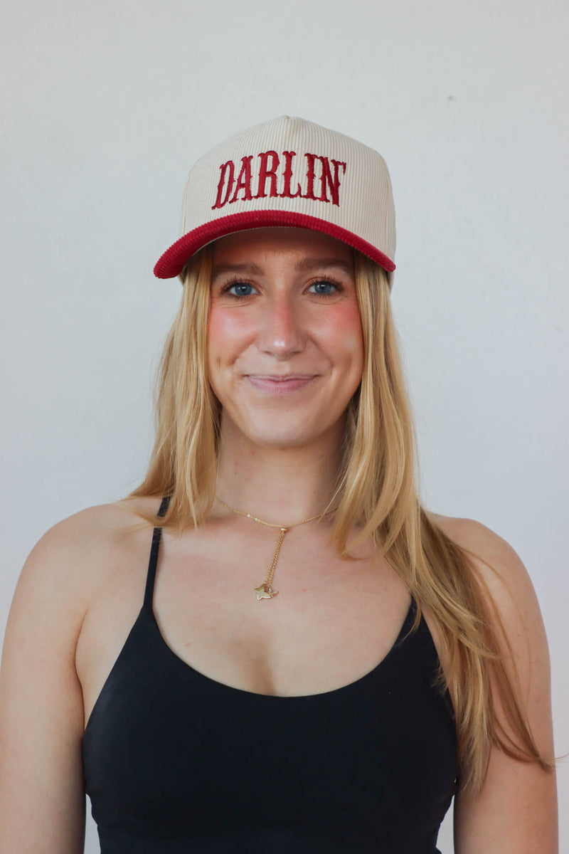 girl wearing cream & red "darlin'" hat