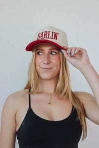 girl wearing cream & red "darlin'" hat