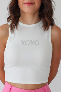 girl wearing white "xoxo" tank top