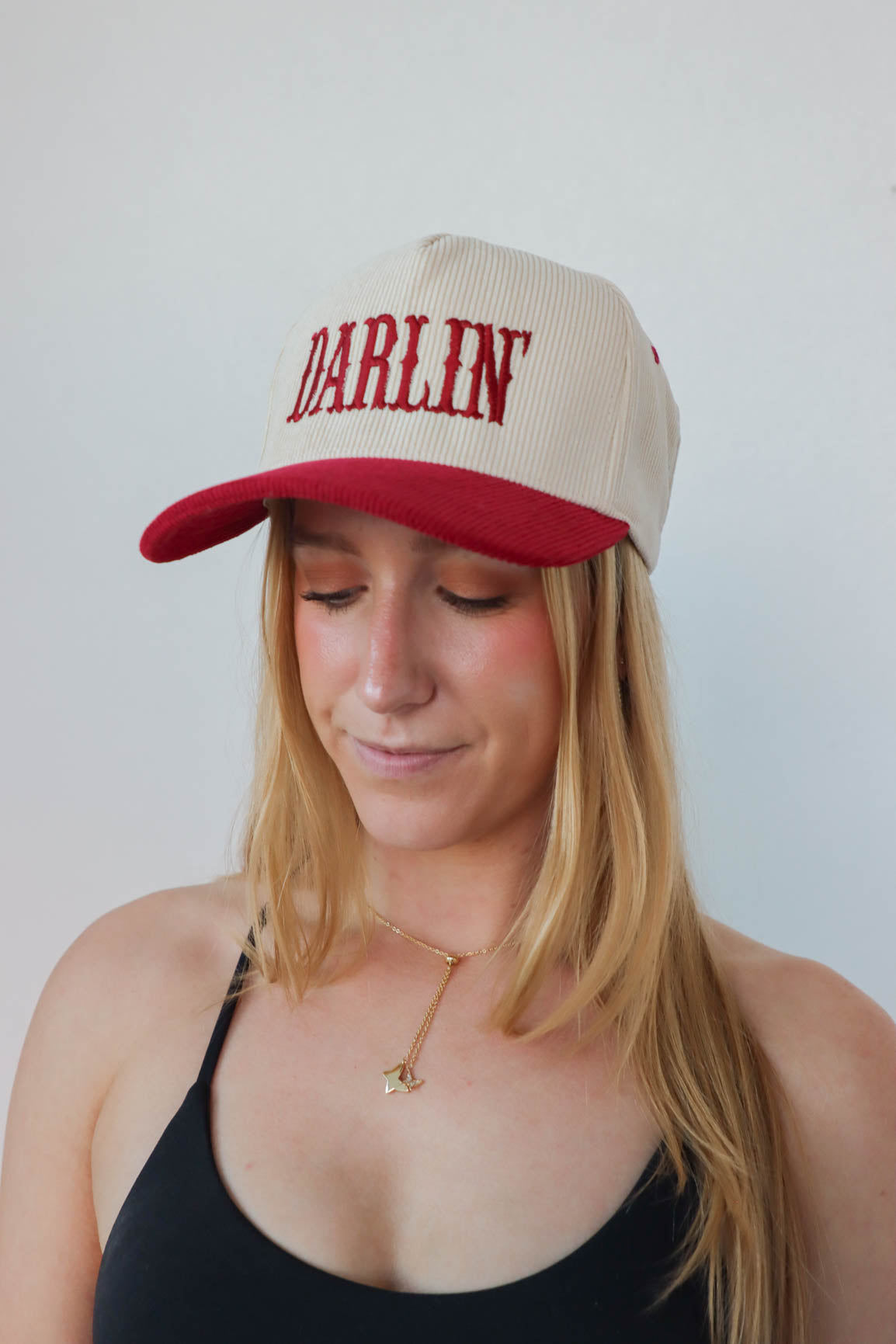 girl wearing cream & red "darlin'" hat