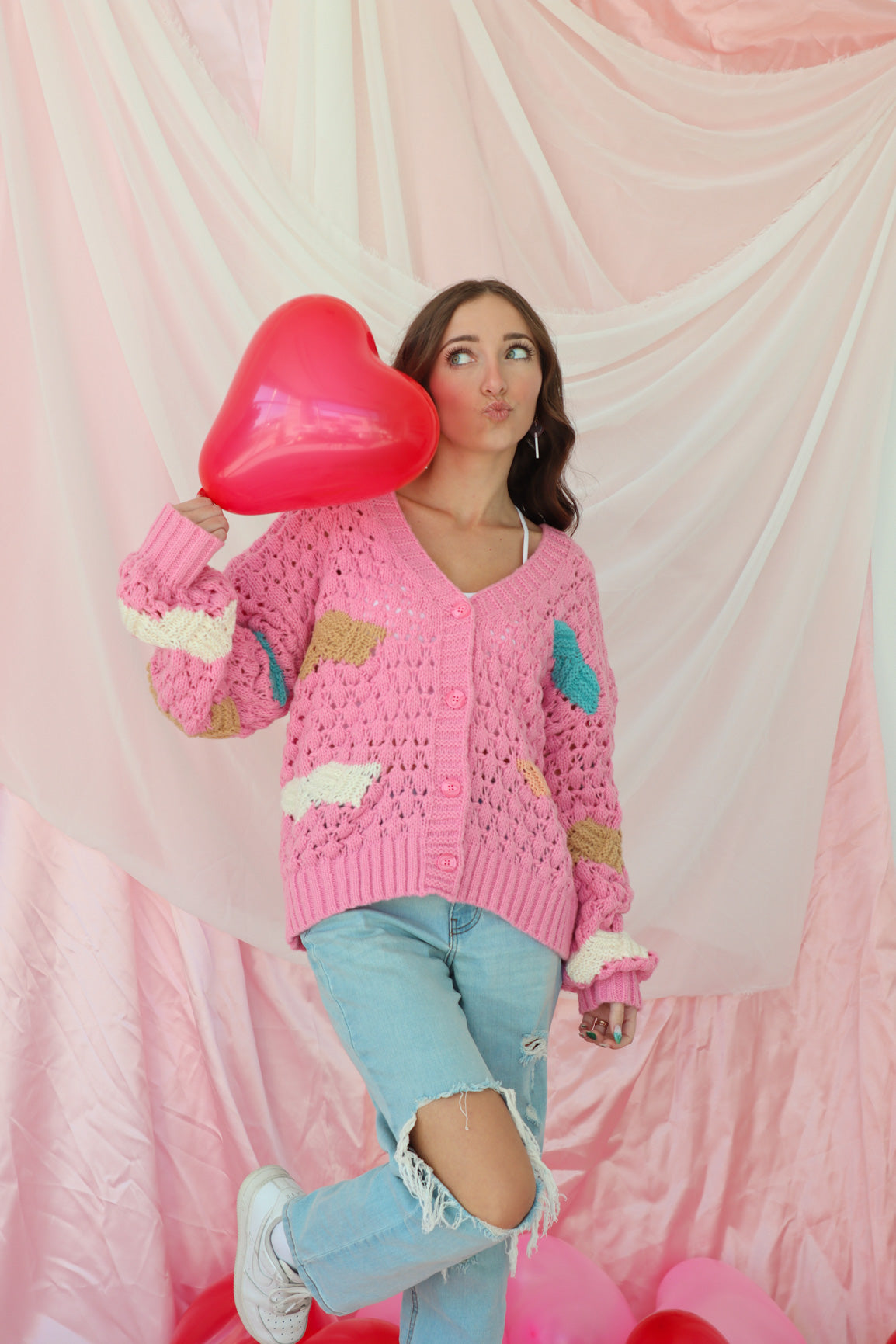girl wearing pink knit cardigan with cloud pattern