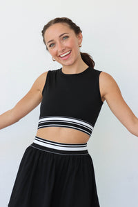 girl wearing black and white athletic set: tank top and skirt