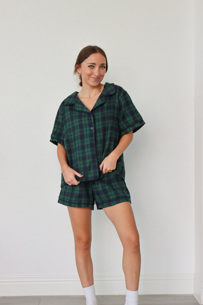 girl wearing dark green and navy plaid pajamas