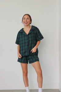 girl wearing dark green and navy plaid pajamas