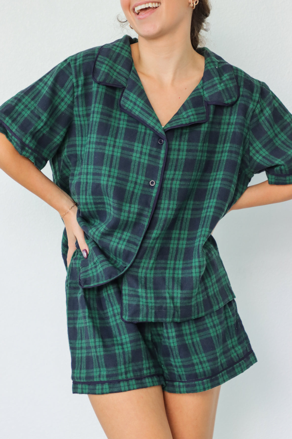 girl wearing dark green and navy plaid pajamas