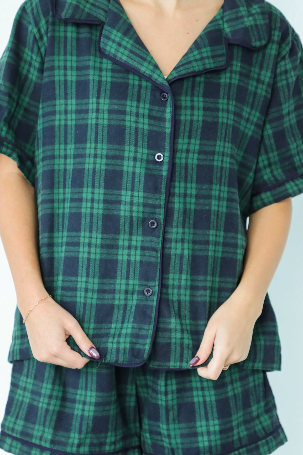 girl wearing dark green and navy plaid pajamas