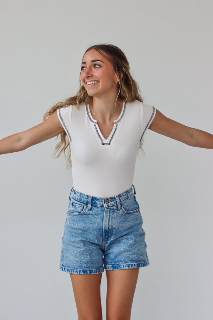 girl wearing white t-shirt bodysuit with black contrast stitching