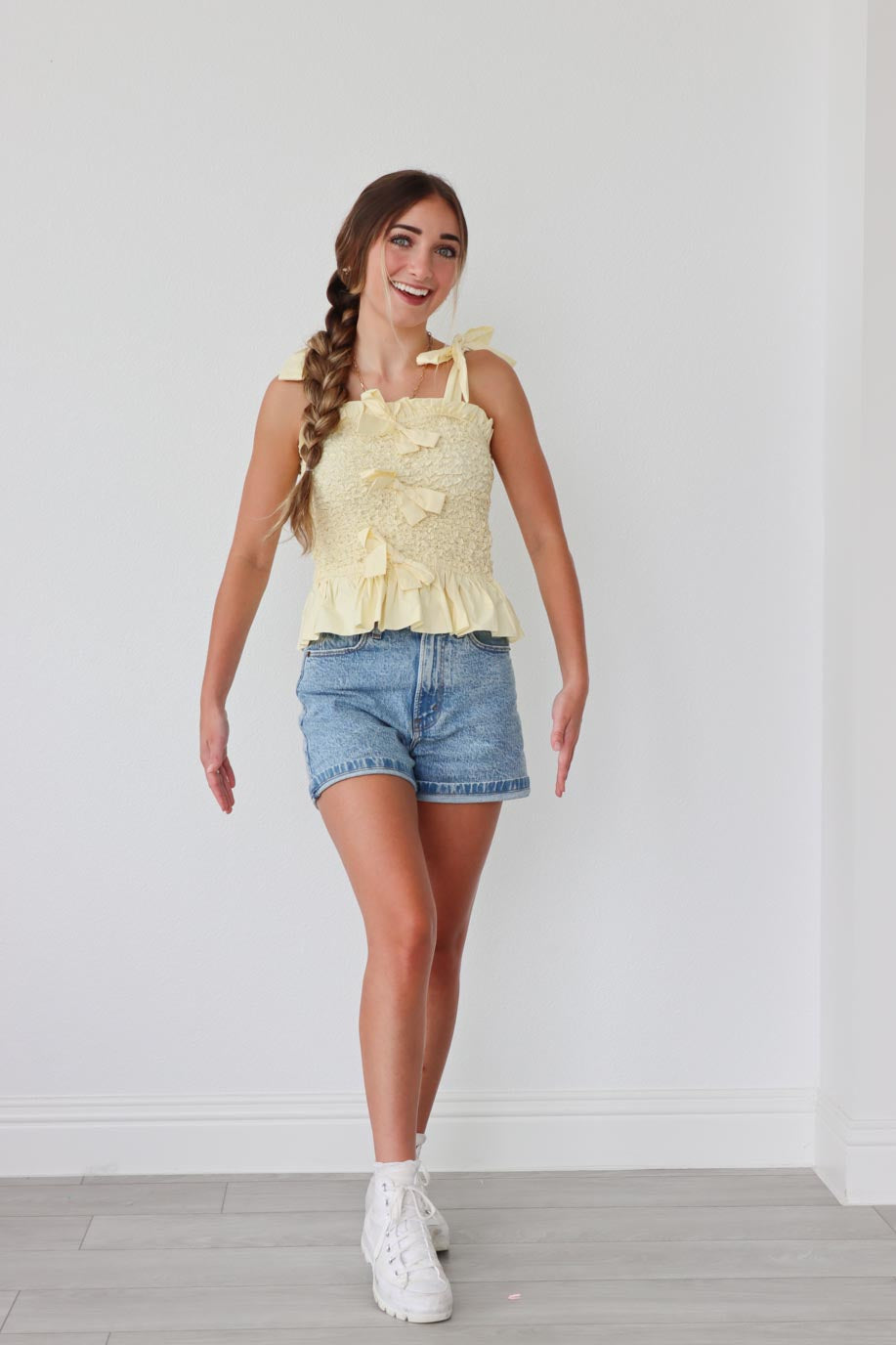 girl wearing yellow tank top with bow detailing