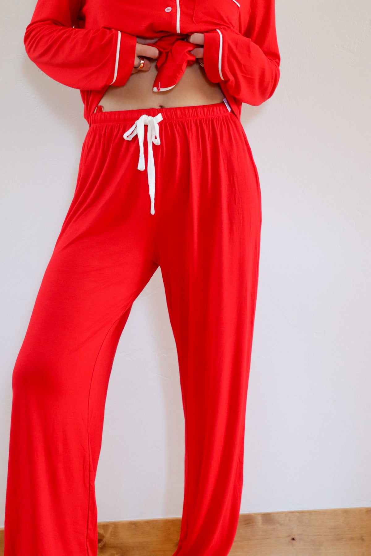 Red tracksuit with white drawstrings on a plain background