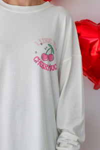 girl wearing white long sleeve "i like you cherry much" graphic tee