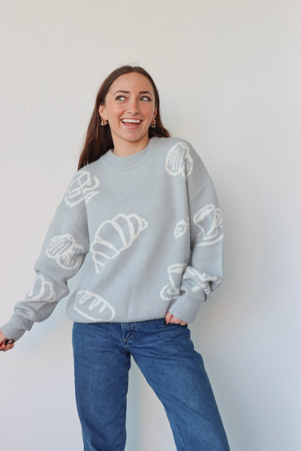 girl wearing light blue croissant and coffee sweater