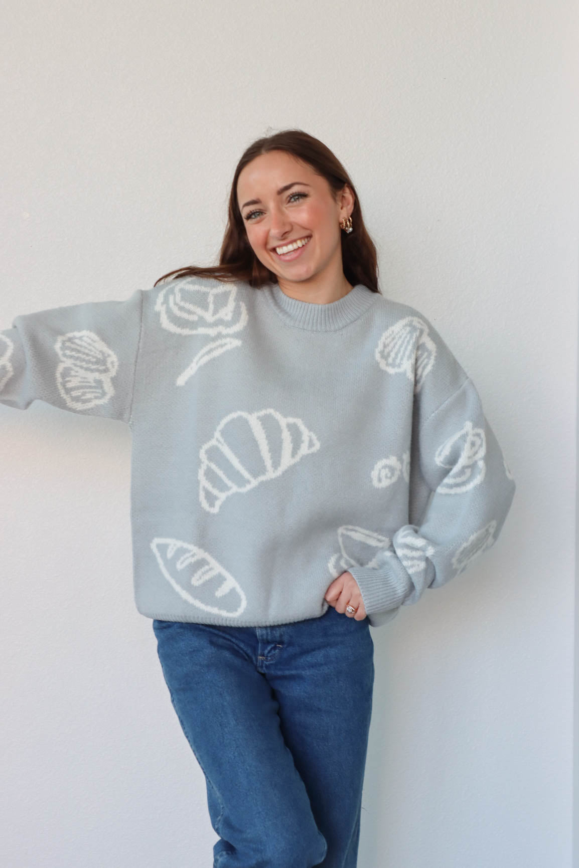 girl wearing light blue croissant and coffee sweater