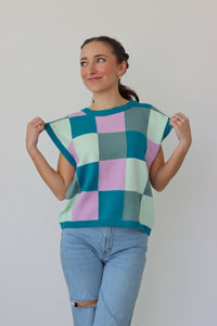 girl wearing blue, green, and purple knit short sleeve top