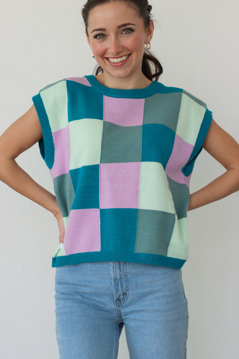 girl wearing blue, green, and purple knit short sleeve top