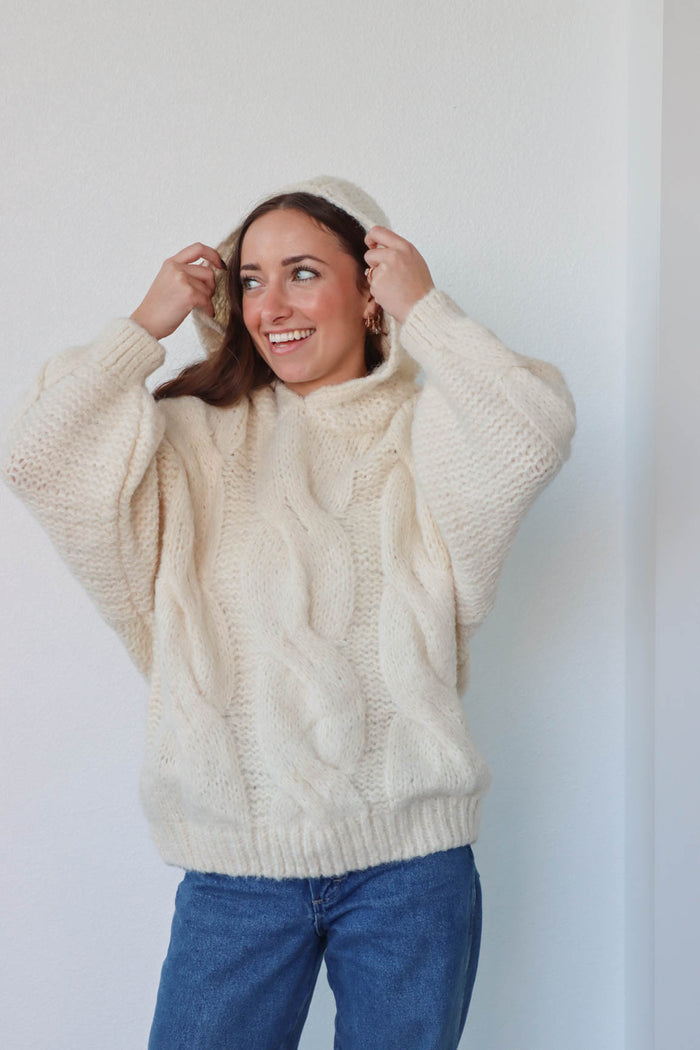 girl wearing cream cable knit hoodie