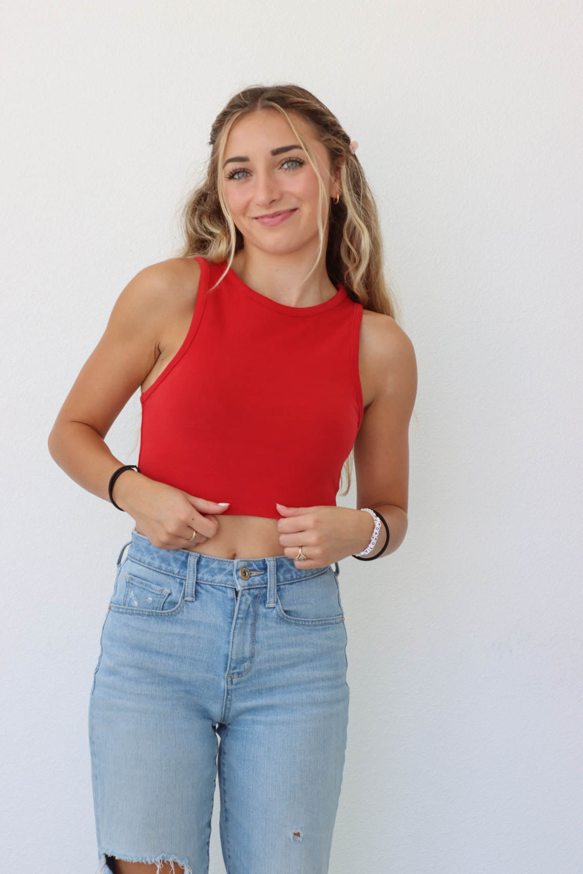 girl wearing red tank top with buckle detailing on the back