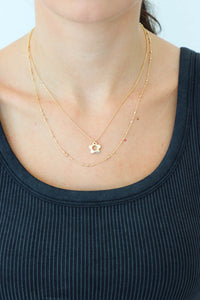 girl wearing gold flower layered necklace