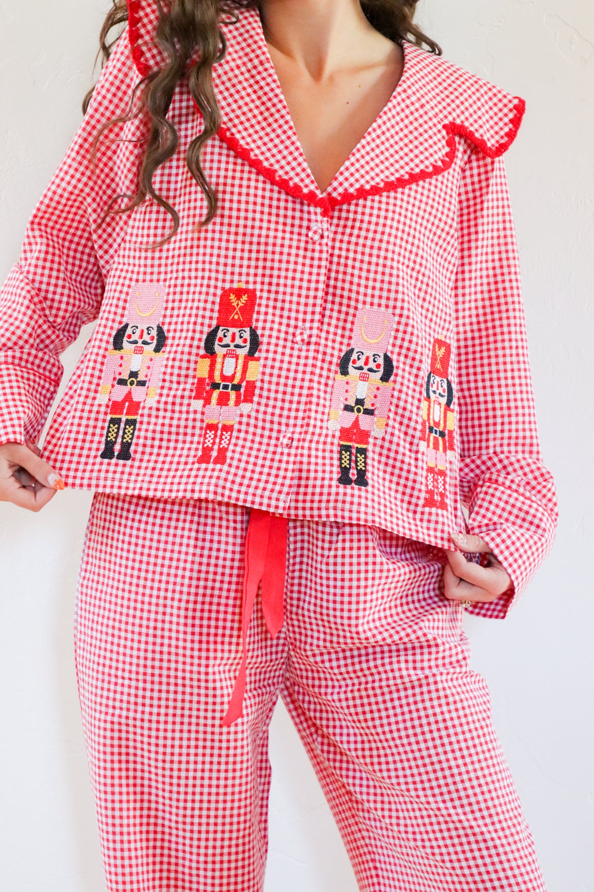 Red gingham pajama set with nutcracker design on a white background