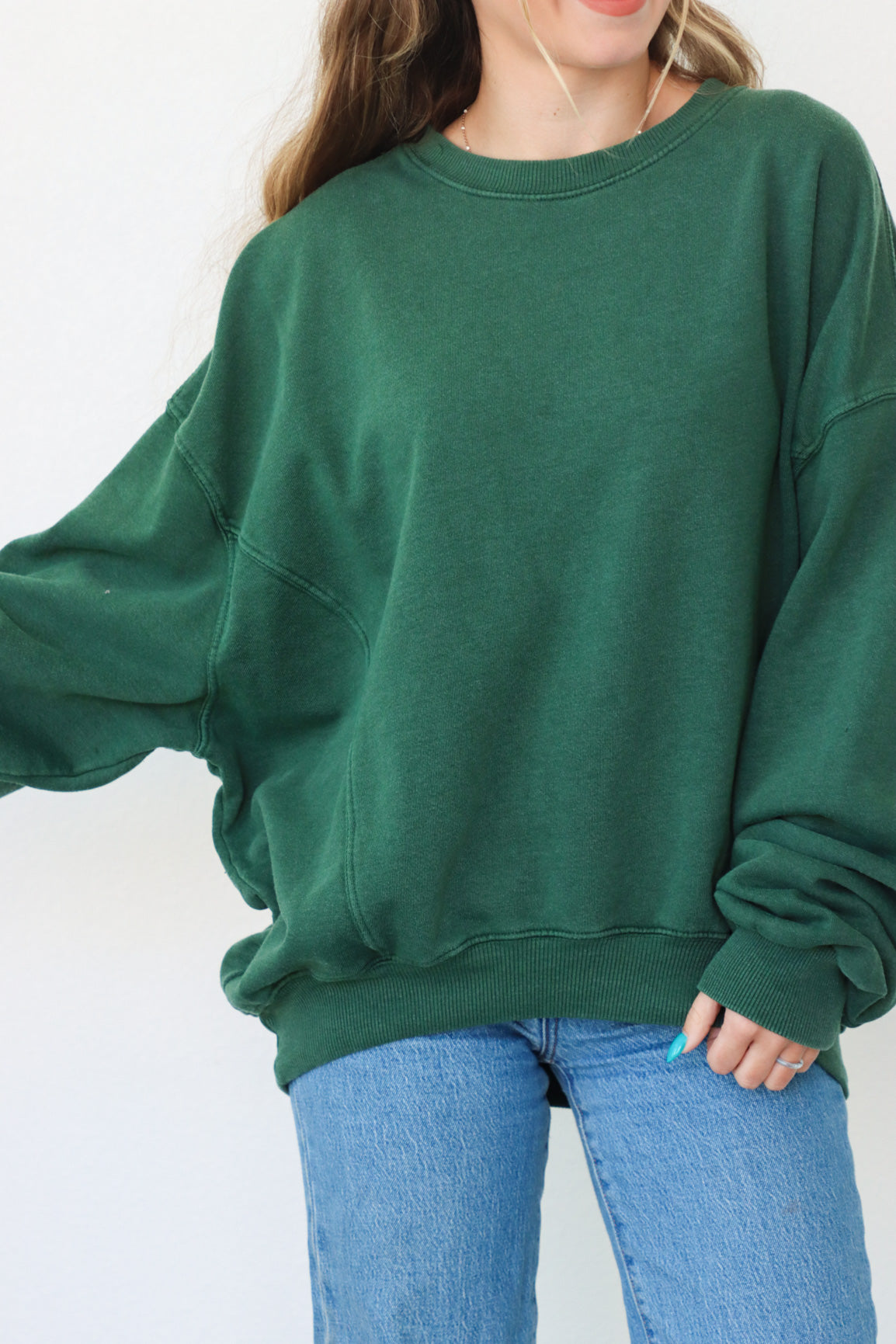 girl wearing dark green crewneck sweatshirt