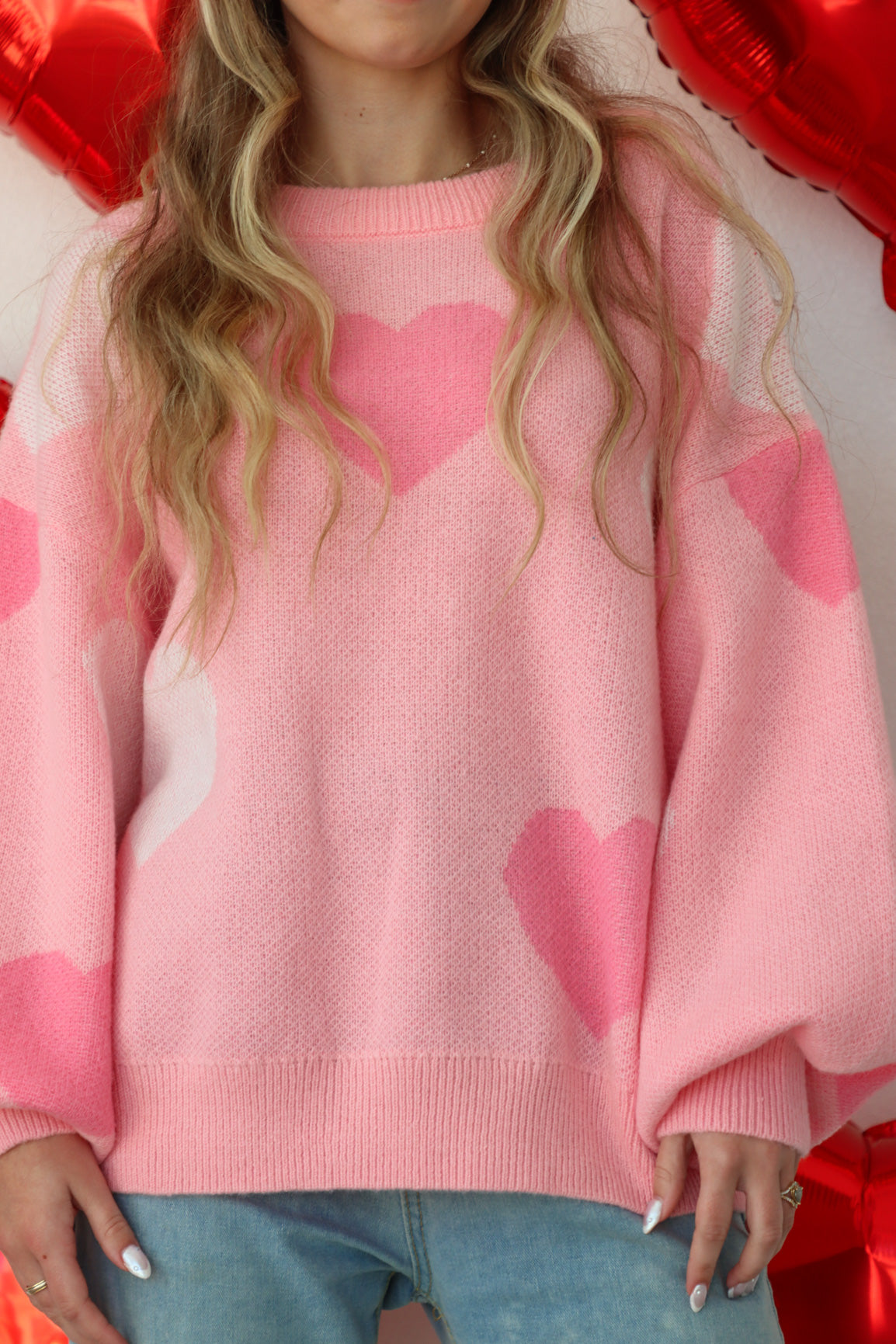 girl wearing pink heart knit sweater