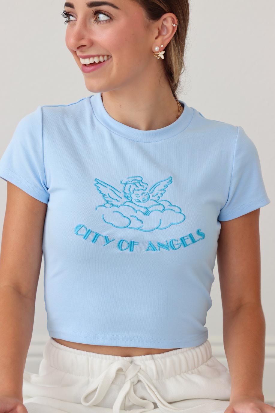 girl wearing blue "city of angels" tee