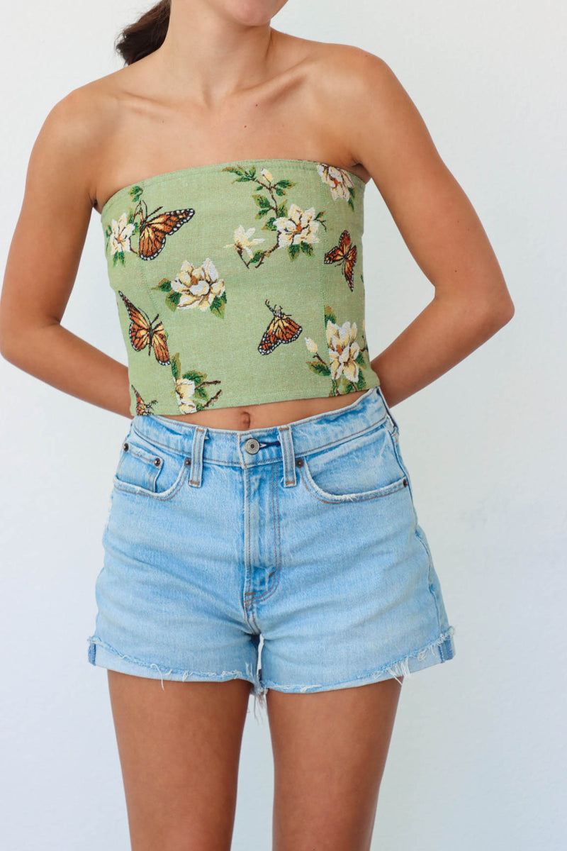 girl wearing green butterfly floral corset top