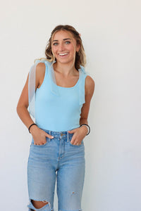 girl wearing light blue tank top bodysuit with tulle straps