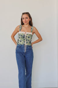 girl wearing green & blue floral corset top