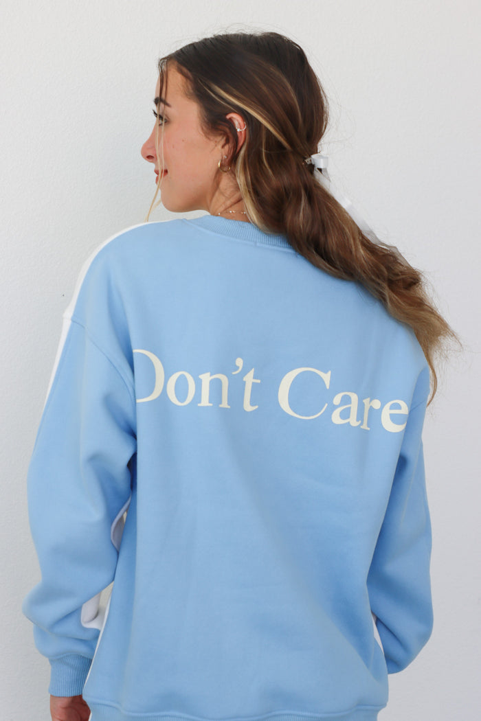 girl wearing color block sweatshirt with "Don't Know" on the front and "Don't Care" on the back