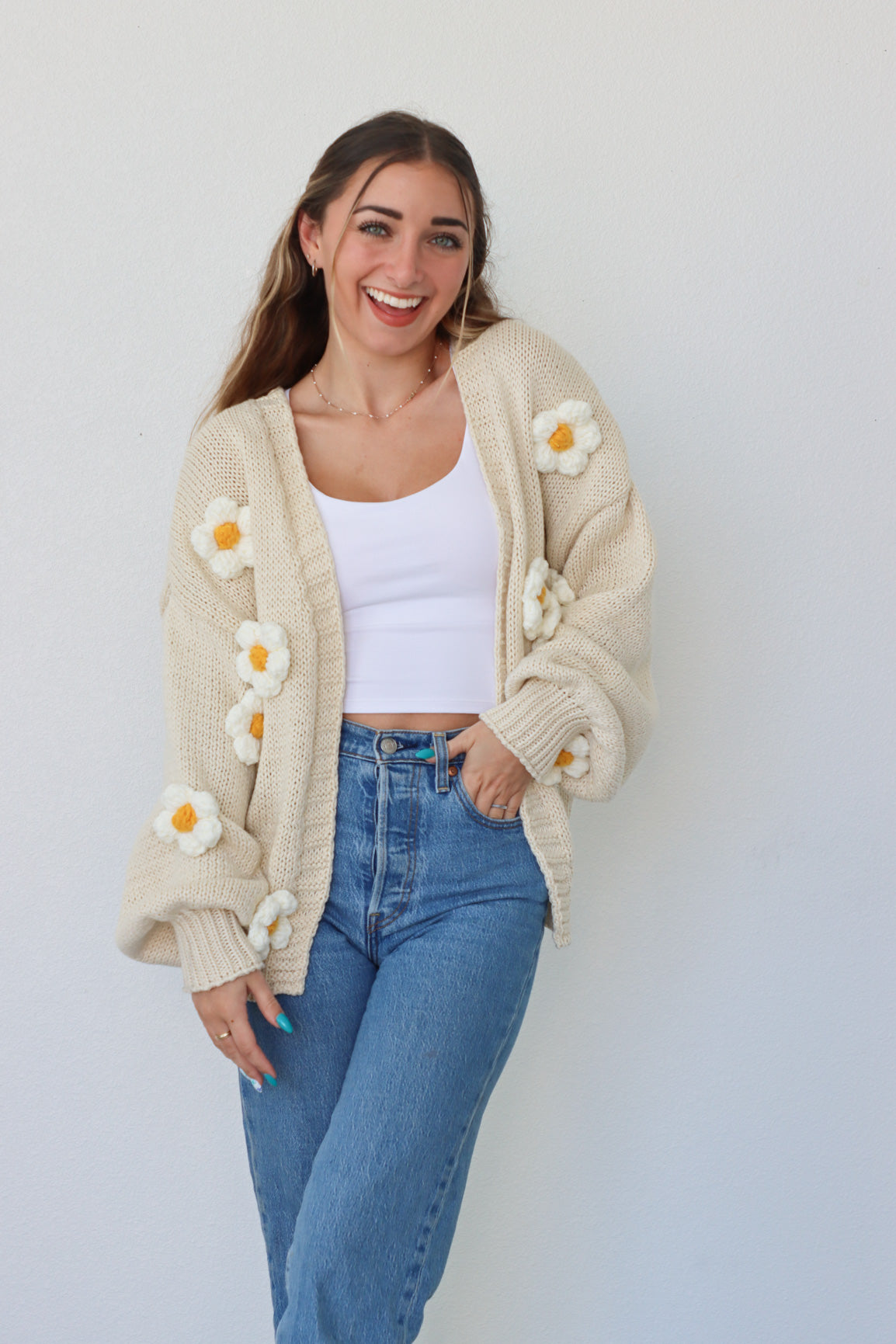 girl wearing cream knit cardigan with daisies
