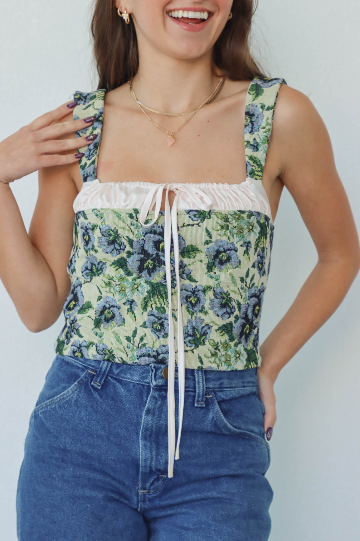 girl wearing green & blue floral corset top