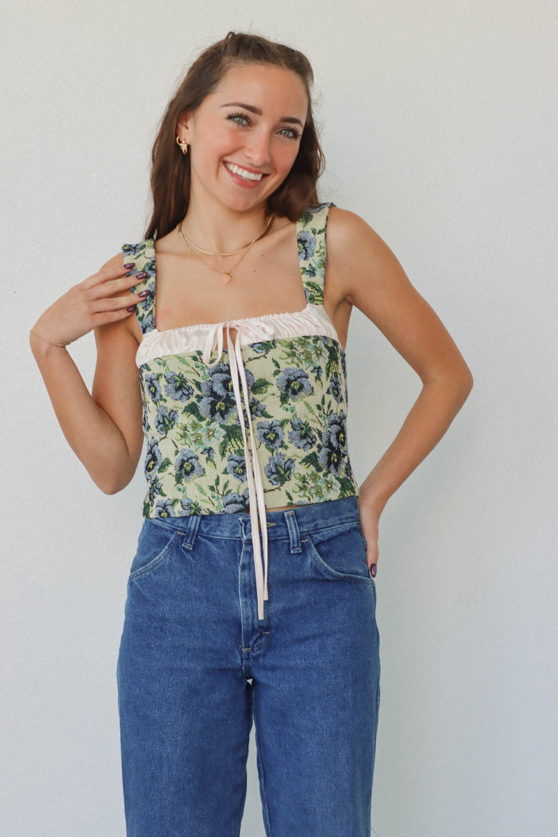 girl wearing green & blue floral corset top