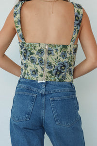 girl wearing green & blue floral corset top