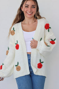 girl wearing cream knit cardigan with roses