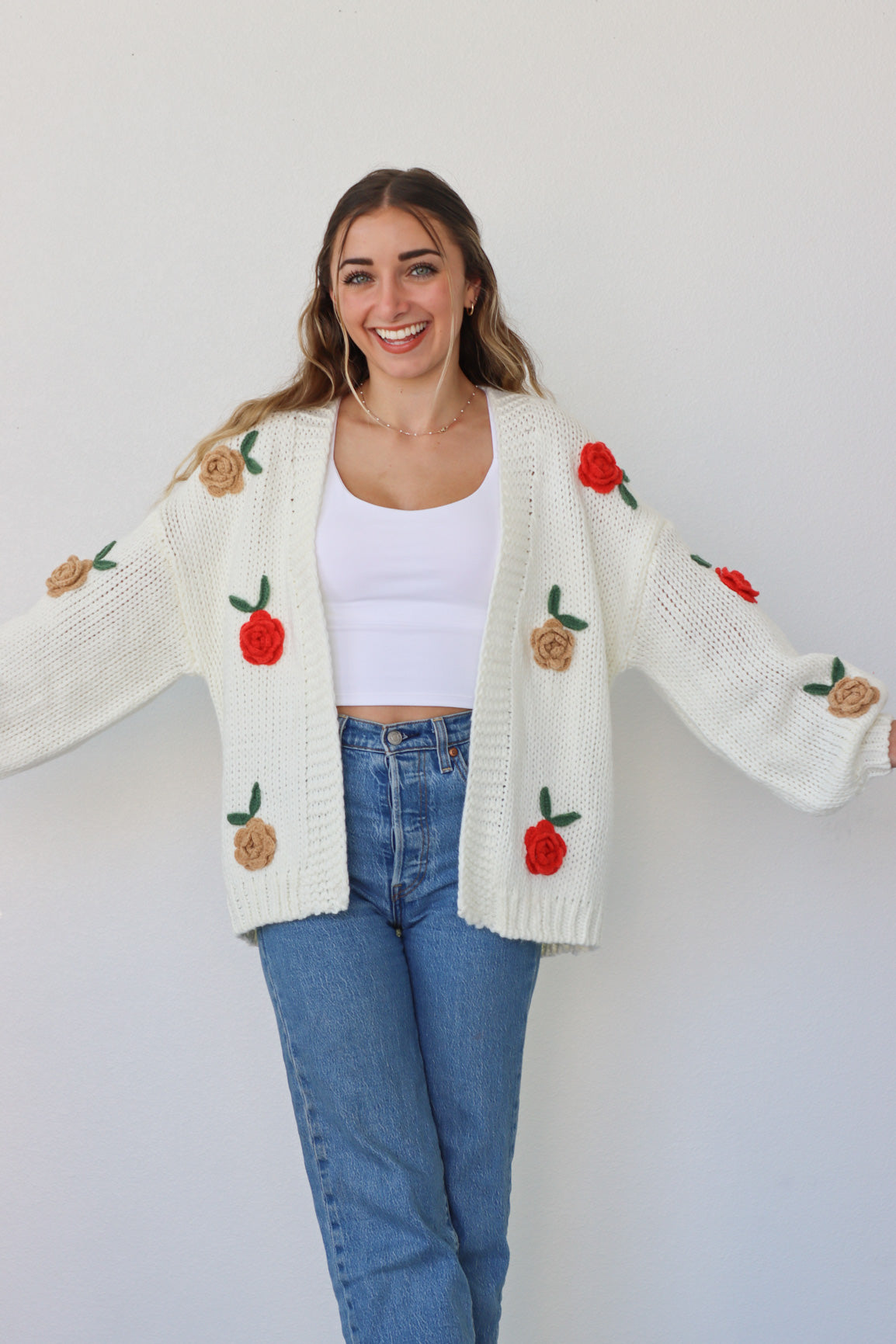 girl wearing cream knit cardigan with roses