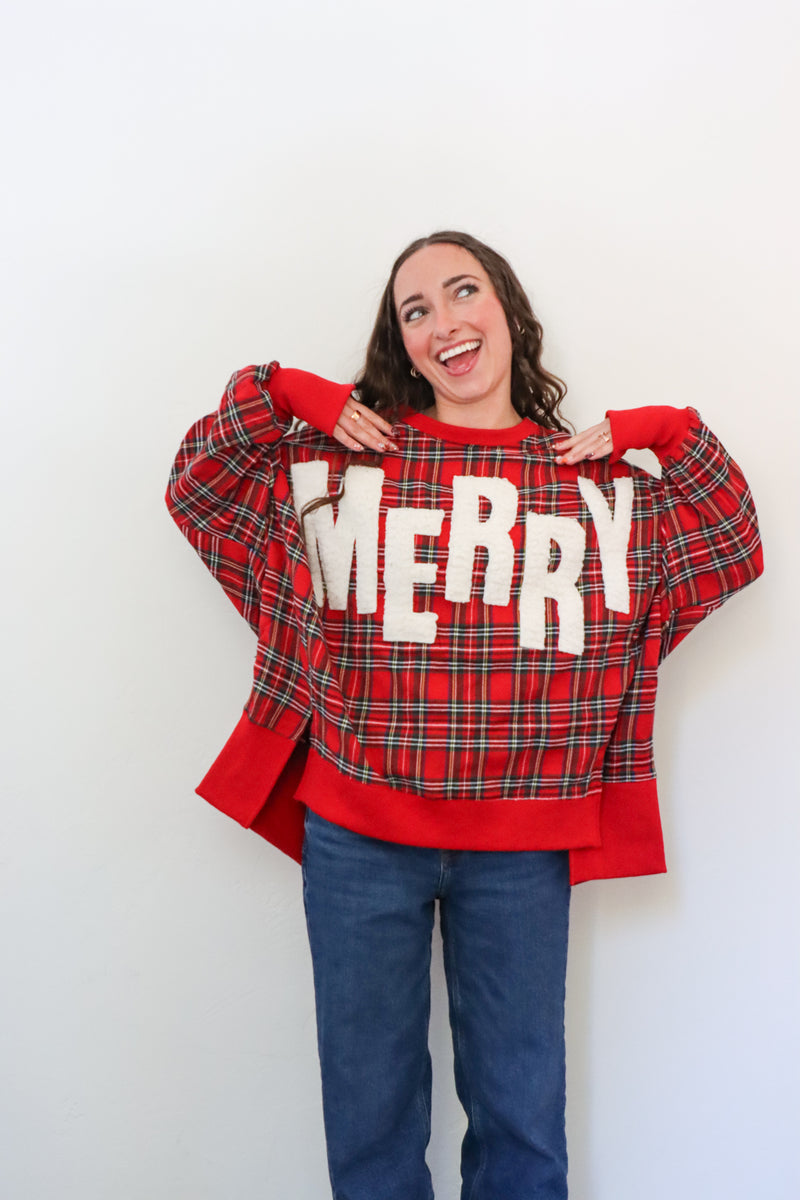 Person wearing a red plaid sweater with 'MERRY' text on a white background