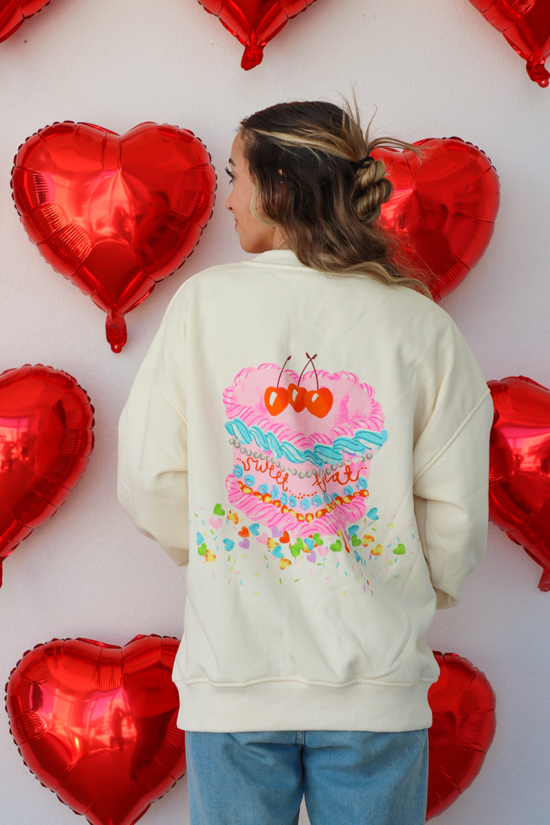 girl wearing cream crewneck sweatshirt with "sweet heart" and "sweet treat"graphic