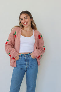 girl wearing pink knit cardigan with cherries