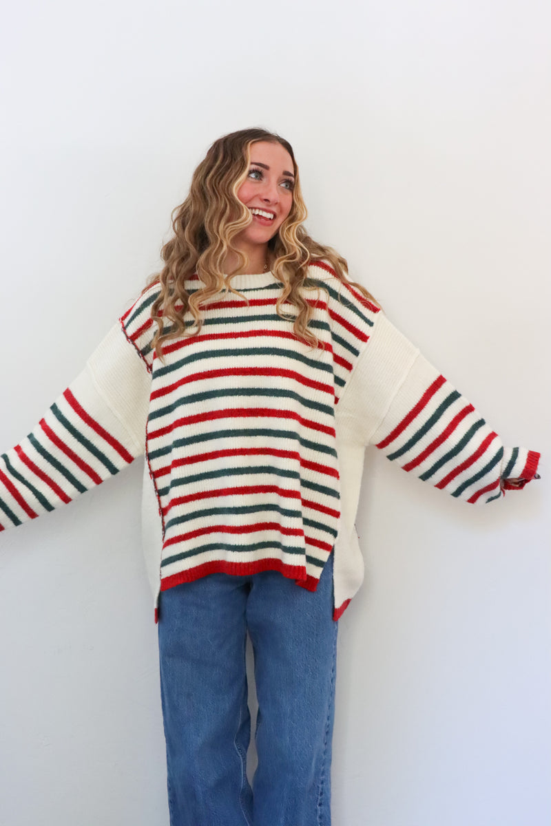 Person wearing a striped sweater and jeans against a white background