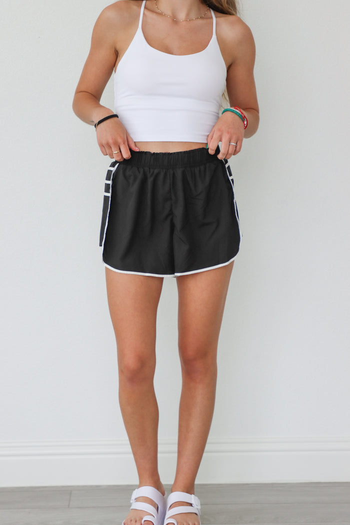 girl wearing black athletic shorts with ruffle details