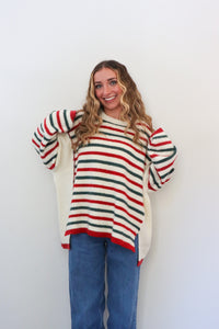 Woman wearing a striped sweater and blue jeans against a white background