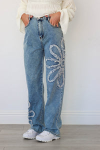 girl wearing blue jeans with flower rhinestone detailing