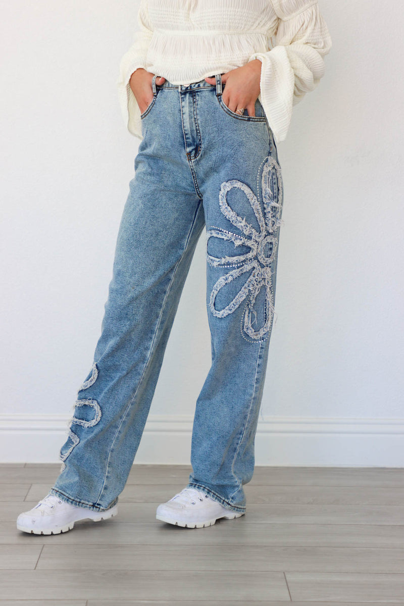 girl wearing blue jeans with flower rhinestone detailing