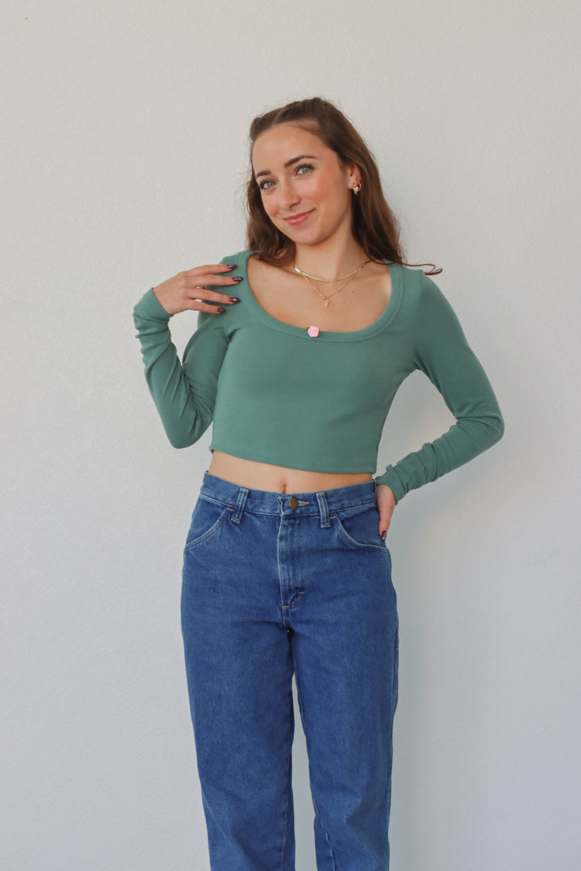 girl wearing teal long sleeved crop top