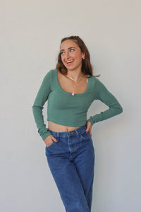 girl wearing teal long sleeved crop top