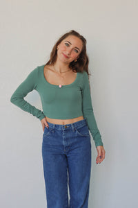 girl wearing teal long sleeved crop top