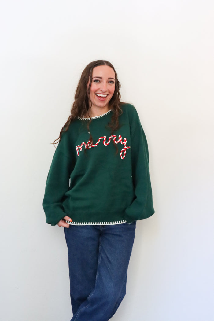 Woman wearing a green sweater with red text against a white background