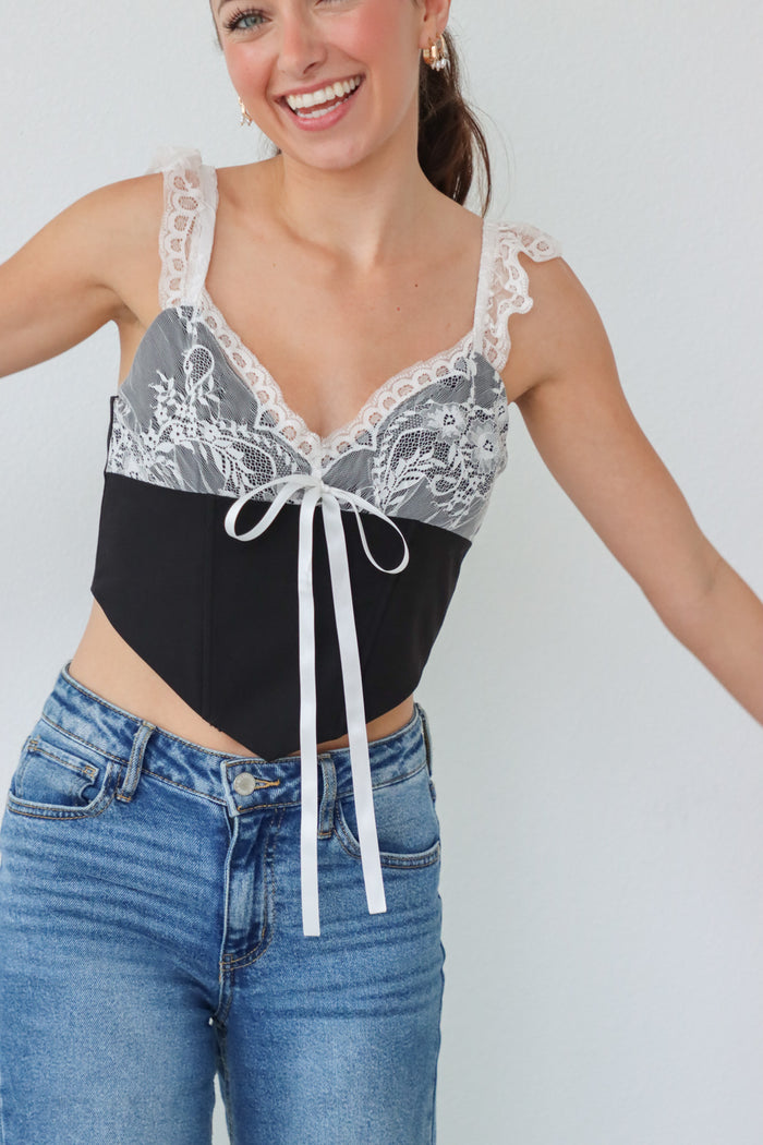 girl wearing black corset top with white lace detailing
